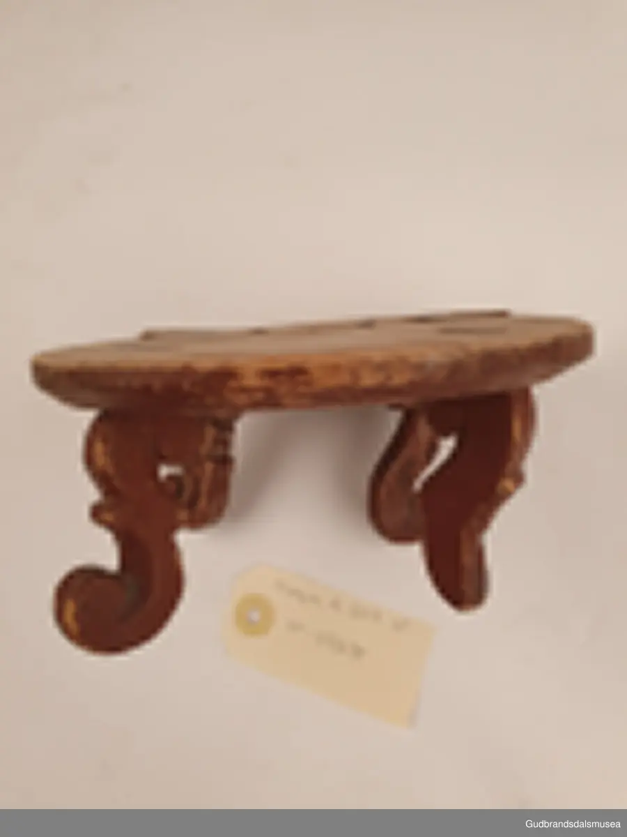 Smørbrikke i tre med 4 føtter. Føttene er ulikt utformet. En reprasjon på platen med kramper.
Merket med svimerke under FNV

Diameter 17 cm
Høyde 8 cm

Matriale; tre
Teknikk; utskjøring, sage, spikke, pusse, dreie