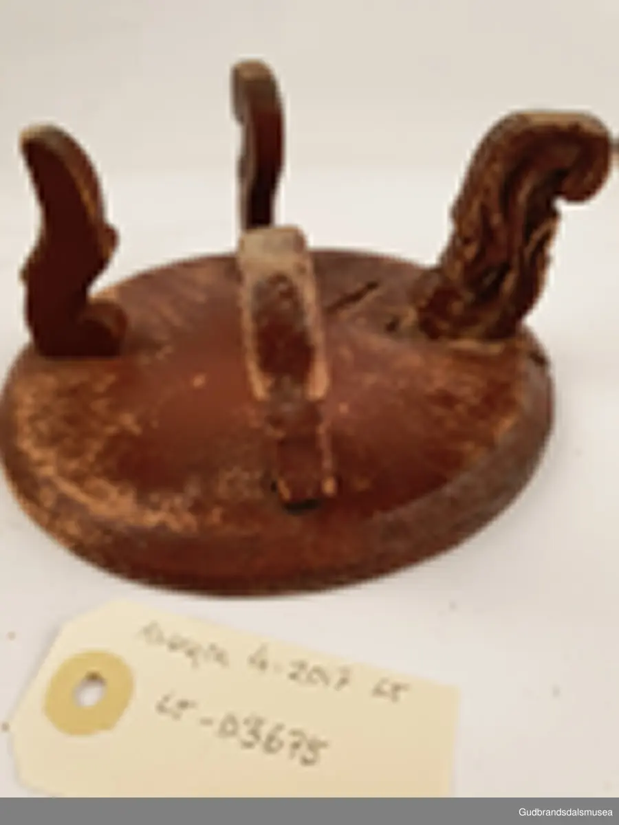 Smørbrikke i tre med 4 føtter. Føttene er ulikt utformet. En reprasjon på platen med kramper.
Merket med svimerke under FNV

Diameter 17 cm
Høyde 8 cm

Matriale; tre
Teknikk; utskjøring, sage, spikke, pusse, dreie