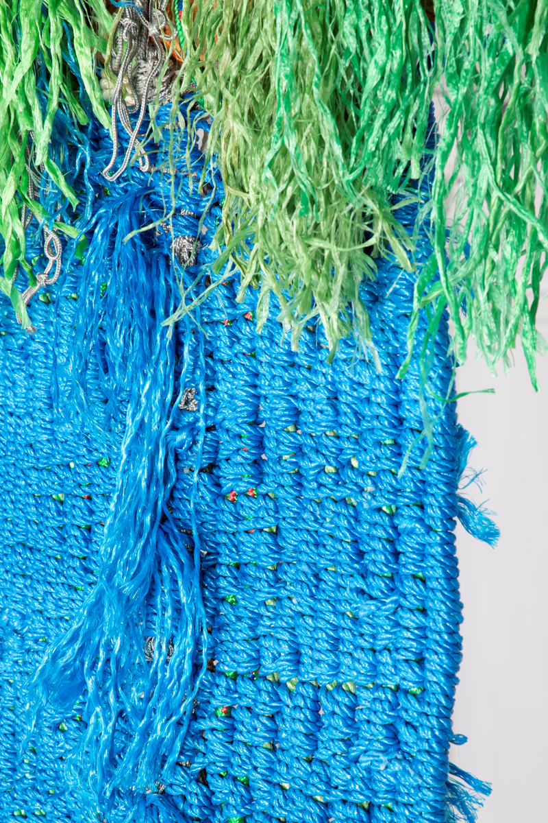 Avlangt vev. Islett av ull, lin, sisal og nylon på renning av nylontau. I den nederste delen av veven, etter at islettet er avsluttet, så henger nylontauet løst og avsluttes i dusker. Veven er remset opp i toppen og festet til en vedskie. Renningstrådene er også limt fast til hverandre.