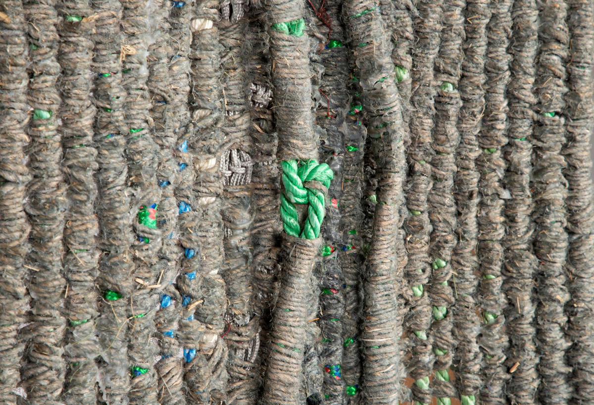 Avlangt vev. Islett av ull, lin, sisal og nylon på renning av nylontau. I den nederste delen av veven, etter at islettet er avsluttet, så henger nylontauet løst og avsluttes i dusker. Veven er remset opp i toppen og festet til en vedskie. Renningstrådene er også limt fast til hverandre.