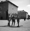 Kamratmötet, I 11. Tre herrar i uniform på kaserngården.