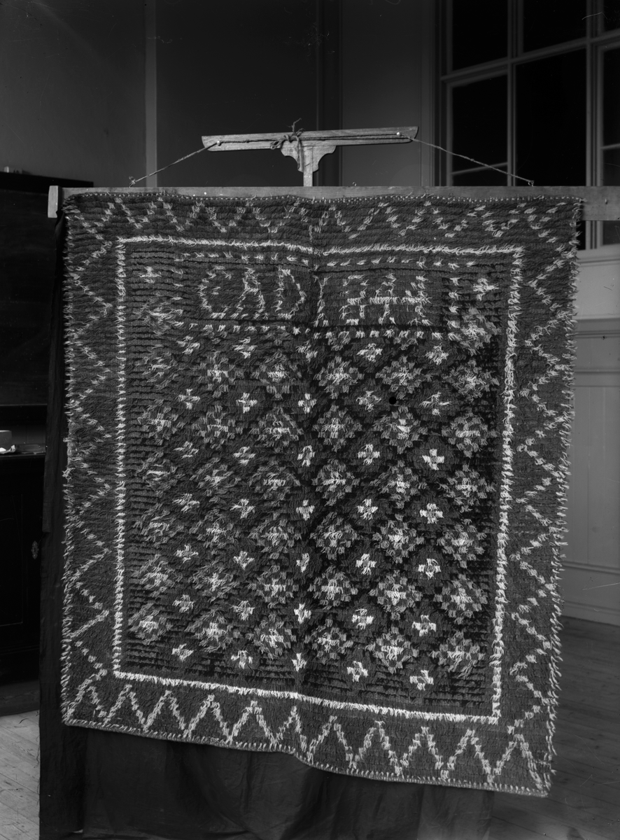 Rya märkt "CAD 1844".

Garnprov i kuvert med följande information: Rya, flossa, 157 x 169 cm, 20 rör på 10 cm, varp linne, inslag ullgarn, mönstergarn 2 trådigt ullgarn, Nockans längd utanför knuten 23mm, trådantal i nockan 2, inslag mellan nockraderna 17mm.