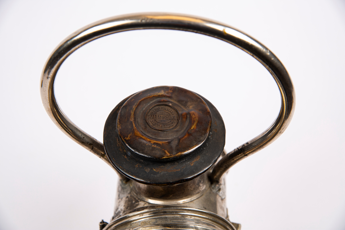 "Til karbid."
NTM: "Lampen har tilhørt et av de små "Montania"
bensinlokomotiv som kom til Underbergstollen i 1912.
Brennmaterialet er carbid - acetylgass.