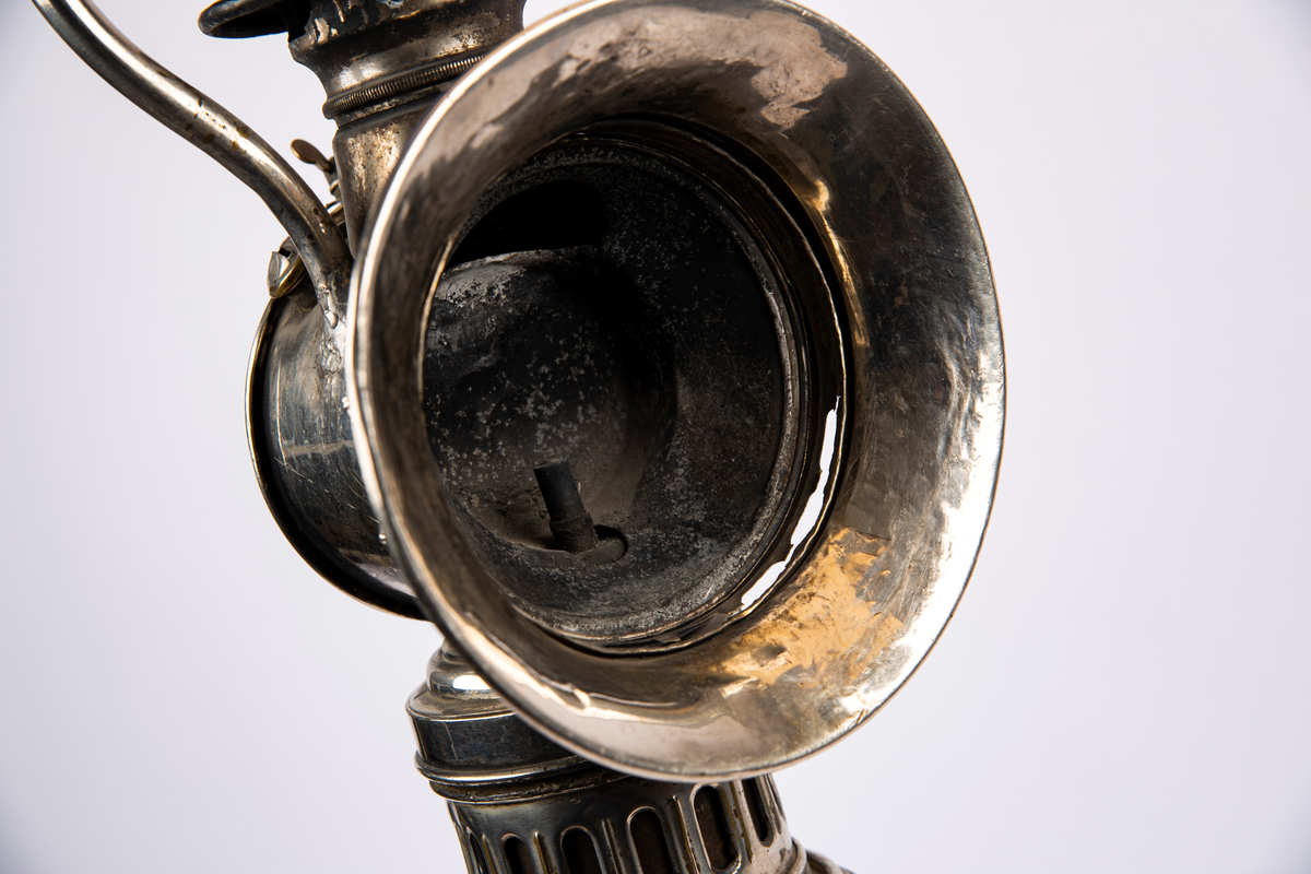 "Til karbid."
NTM: "Lampen har tilhørt et av de små "Montania"
bensinlokomotiv som kom til Underbergstollen i 1912.
Brennmaterialet er carbid - acetylgass.
