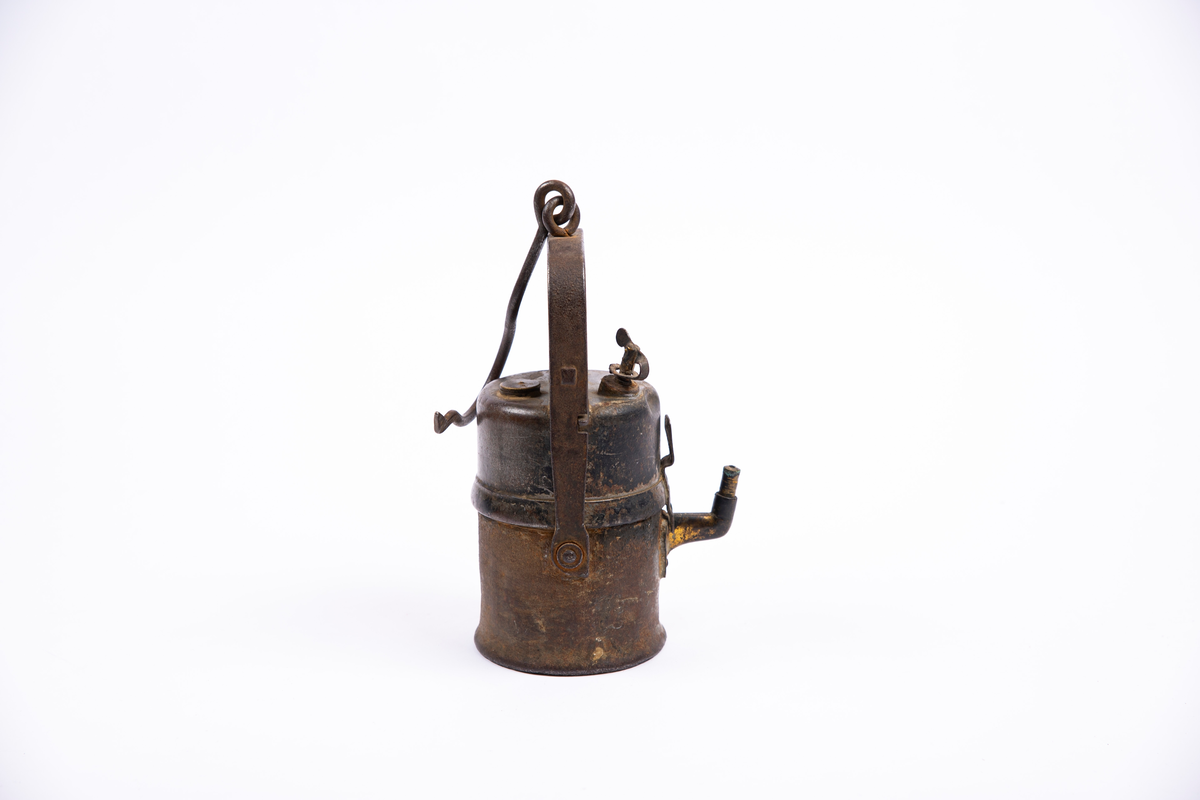 "Grubelamper.Karbid lamper."
NTM:"Dette er en samling av de forskjellige typer
gruvelamper som har vært brukt ved Sølvverket. Disse gir et
godt lys er praktiske og lette å betjene. Det var disse som
avløste oljelampen i 1910 og har siden ikke vært forandret i
prinsippet." Var tidligere registrert som BVM 133, se denne.
Med reflektorfeste.