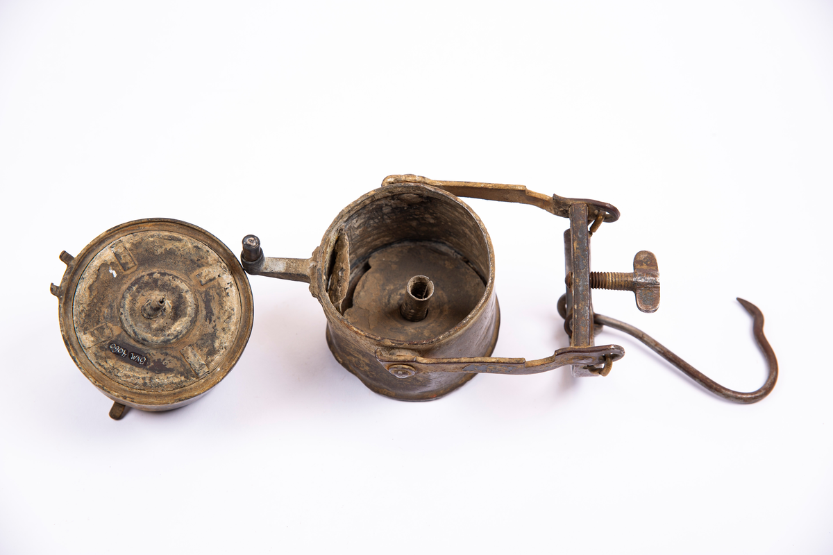 "Grubelamper.Karbid lamper."
NTM:"Dette er en samling av de forskjellige typer
gruvelamper som har vært brukt ved Sølvverket. Disse gir et
godt lys er praktiske og lette å betjene. Det var disse som
avløste oljelampen i 1910 og har siden ikke vært forandret i
prinsippet." Var tidligere registrert som BVM 133, se denne.
Utstilt i to deler, reflektorfeste.