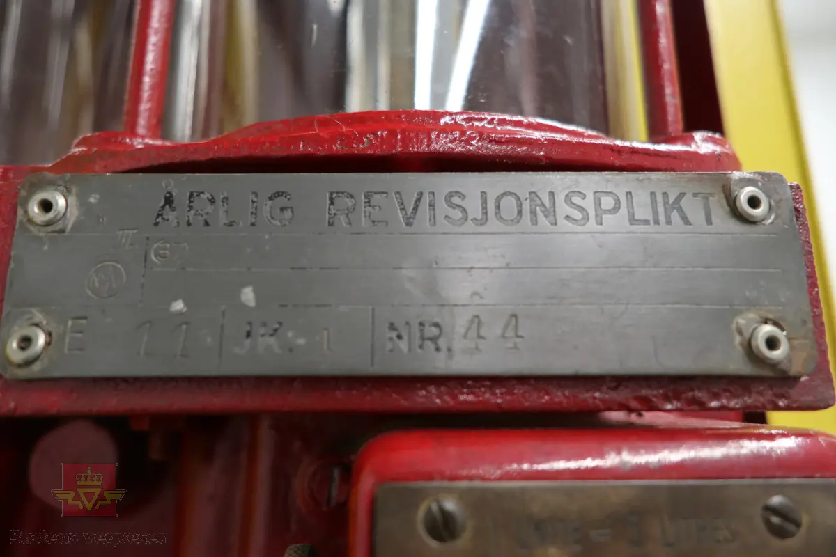 Manuell bensinpumpe, sylinderformet, med to dører som kan åpnes. Gul og rød med Shell logo utvendig, rød innvendig med teksten SHELL på dørene. Påskrudd Shell-logo på toppen av pumpa. Innmaten består av to 5-liters måleglass, telleverk, håndpumpe og slange med pumpepistol. Telleverket for en enkel fylling går til 50 liter. Ifølge telleverket ser det ut som det er fylt snaut 7000 liter fra pumpa. Pumpa har merking fra HARDOLL.
Pumpa er pusset opp.