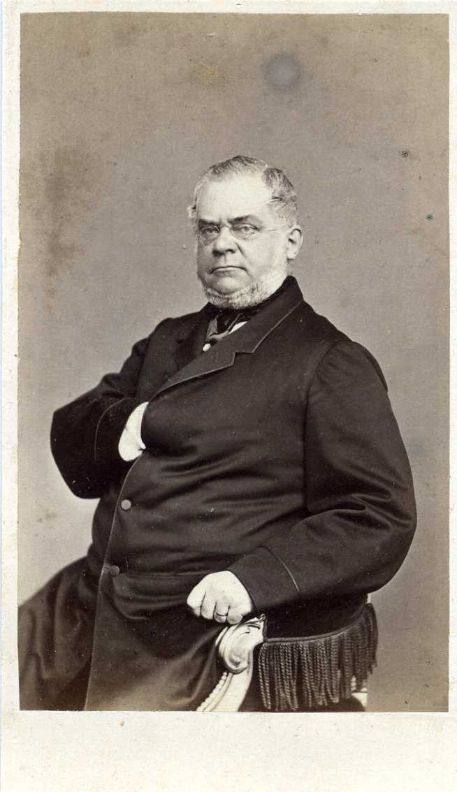 Porträtt av en riksdagsman som sitter på en stol i Napoleon-pose.