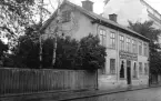 Nedslag i Linköping 1927 där S:t Lars församlings gamla komministerboställe ännu var i bruk. Året därpå skulle staden köpa tomten och efterhand kom huset att stå i vägen för Postverkets expansion. Modemagasinets verksamhet i byggnaden har inte följts för denna presentation.