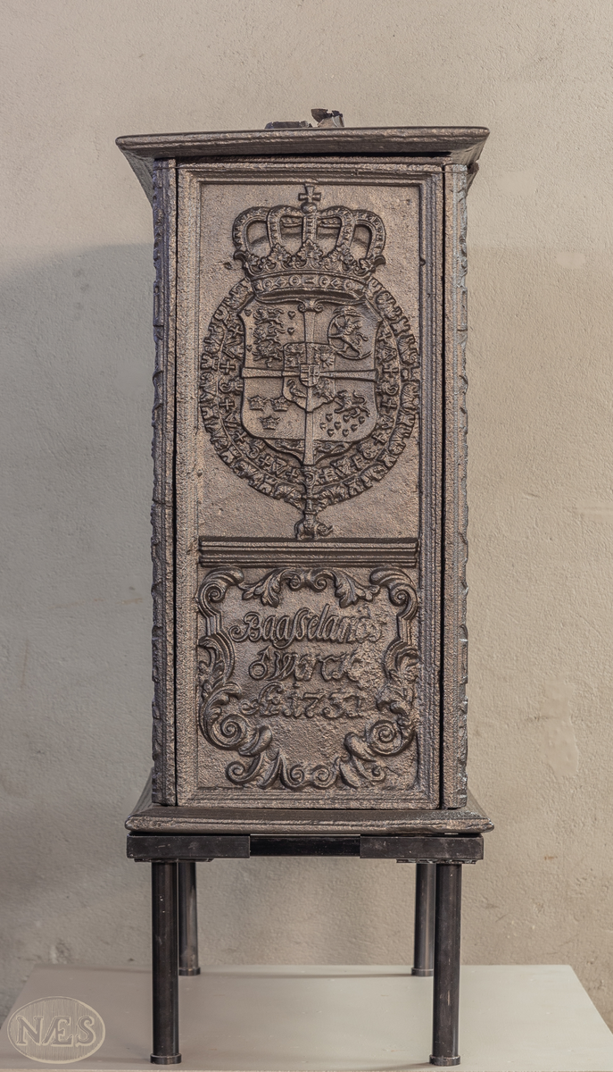 En rektangulær kasseovn med åpning på kortsiden. På langsiden - gjengivelse av tittelbladet til Christian V sin norske lov. På arkitraven over tronstolen C 6 i kronet speilmonogram mellom palmegrener. På de allegoriske figurenes (Overflødighetsgudinnen og Justitia) postamenter Christian VI sitt valgspråk. Faste skinner med geometrisk ornamentikk.
Øverst på kortsiden de forenede rikers våpen omgitt av elefantordens kjede. Nederst påskrift omgitt i en kartusj.