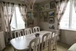 Hörna av ett rum med två gardinklädda (längder) fönster, Kro