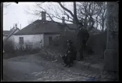 Två personer vid sidan av en kullerstensgata.