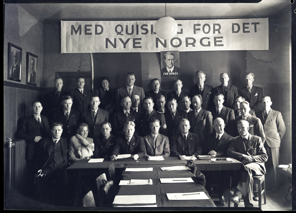 Foto av NS-fylkesstyre i Telemark

Seil: Med Quisling for det nye Norge

Første mann sittende fra venstre er Sagsfører og presseleder Nasjonal samling Olav Lien (f. 1896)

Resten ved bordet i noe usikker rekkefølge:

Ukjent kvinne, bondefører Halvor K. Skjellaug , Dr. O. Hæreid, Karl Henrik Zilgmeyer,  Einar Lunde og Aslak Momrak Haugan

Uidentifiserte personer som nevnes på brevet medhørende foto: 

Frk. (?) Stridsklev, L. Kraft Lund, Sigurd Haugan, Karl Thunes, Anne Kiste (?) Siljan, Sigm(und?) Myhra (?) NS fylkeskontor, 


Påskrift på negativ:
4/4-41

Påskrift på konvolutt negativ lå i: 

4/5 - 41


Påskrift på kovnolutt:

Fylkesstyret NS