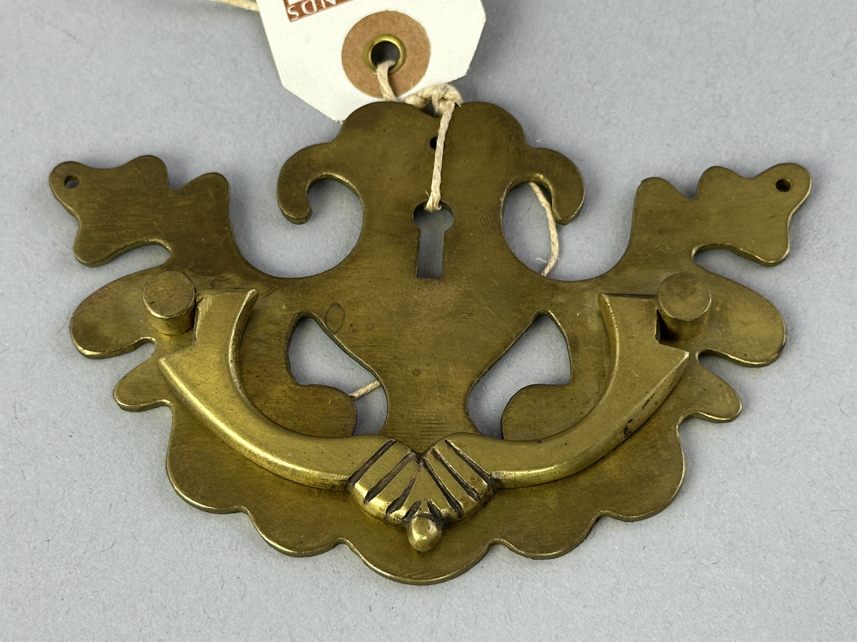 Nyckelhålsbeslag med handtag av mässing till byrå.