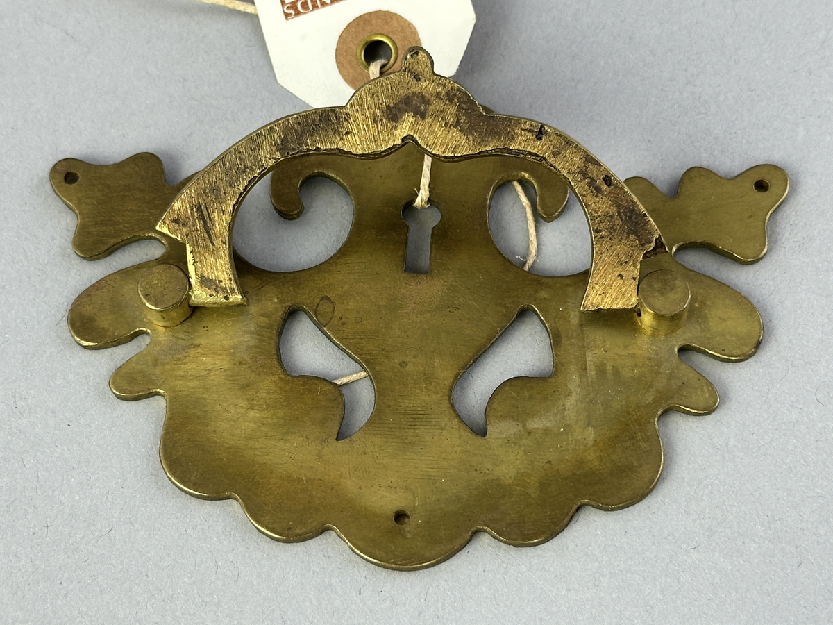 Nyckelhålsbeslag med handtag av mässing till byrå.