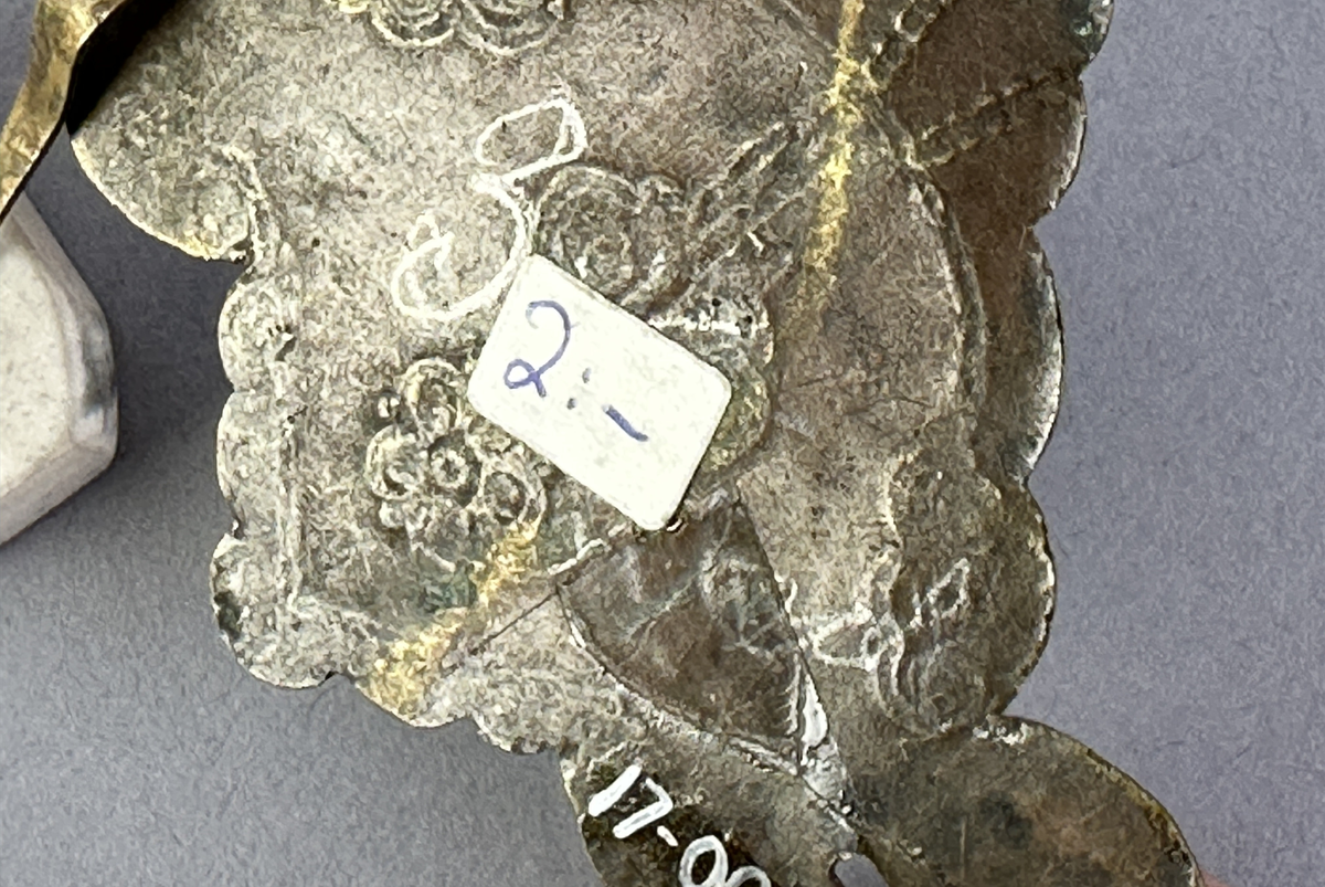 Handtagsbeslag av mässing. Modellerna saknar handtag. Modell a är dekorerad med punsat mönster.