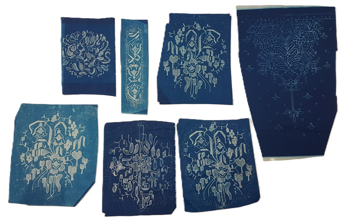 Mapp innehållande många små och stora skisser för spets, de minsta ca 12X12 cm och de större ca 70X100 cm. 
De blå skisserna troligen utförda i tekniken cyanotype, övriga i blyerts eller tusch.