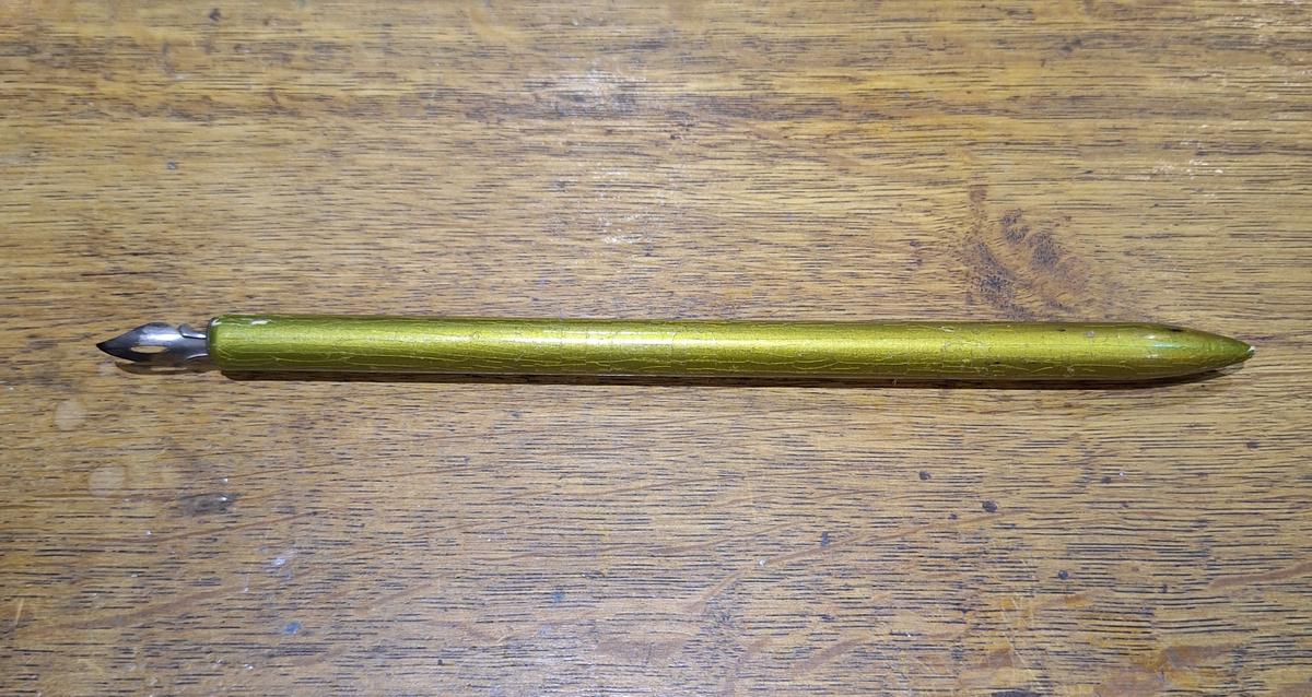 Stålpenna till skrivställ (del A). 
a) ställ av järn
b-c) bläckglas med lock
d) stålpenna med träskaft, guldlackat
e) del av bläckglas
f) elfenbetsbit