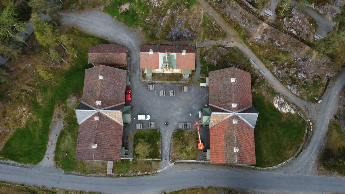 Laftet bygning i to etasjer. Taket tekket med tegl, blikk og skifer.