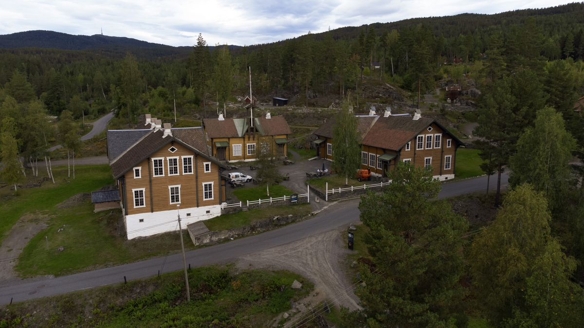 Laftet bygning i to etasjer. Taket tekket med tegl, blikk og skifer.