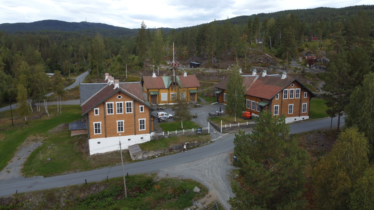 Laftet bygning i to etasjer. Taket tekket med tegl, blikk og skifer.