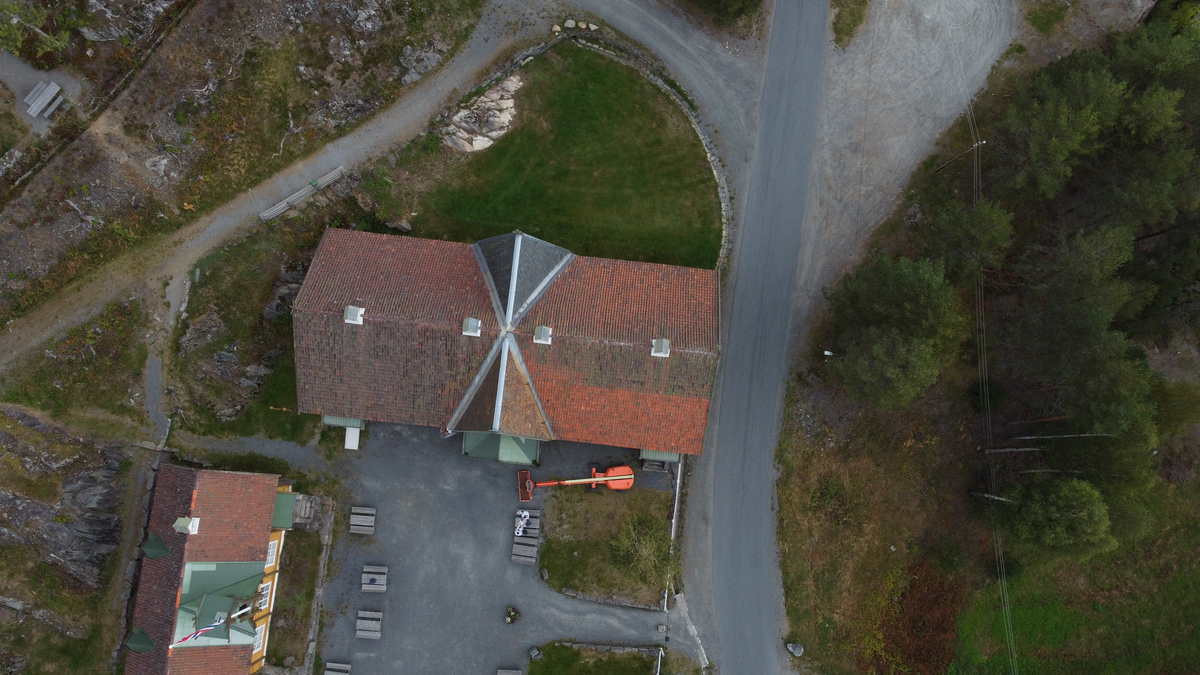 Laftet bygning i to etasjer. Taket tekket med tegl, blikk og skifer.