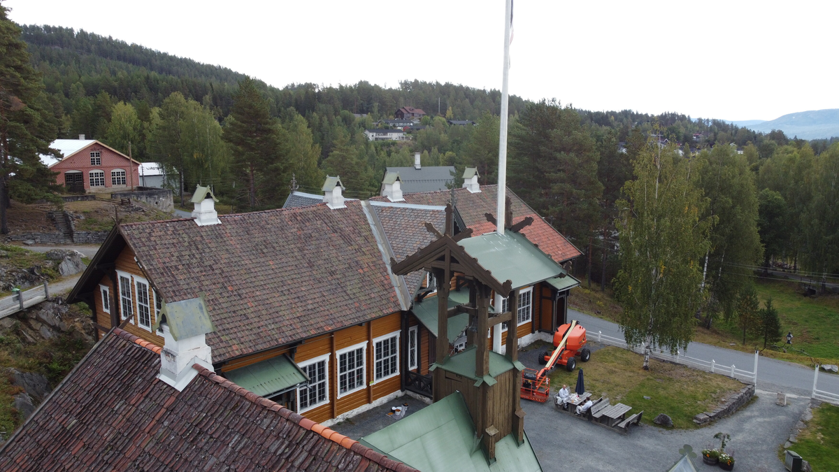 Laftet bygning i to etasjer. Taket tekket med tegl, blikk og skifer.