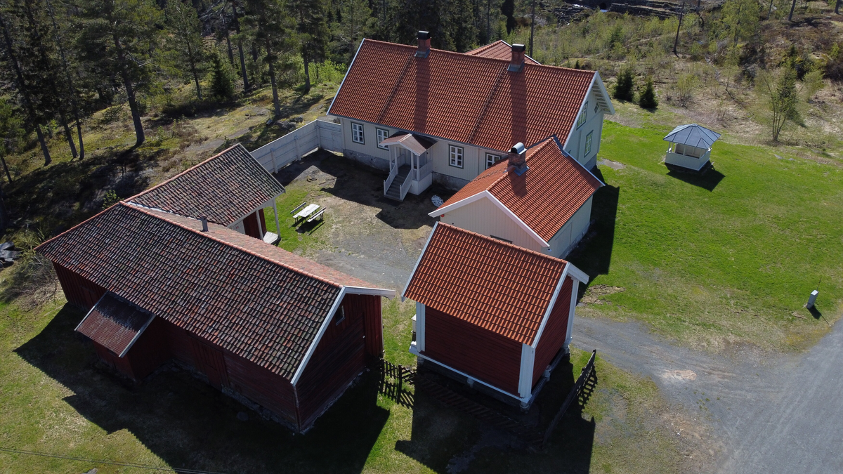 Laftet bygning i to etasjer med kjeller. Tegl på taket.