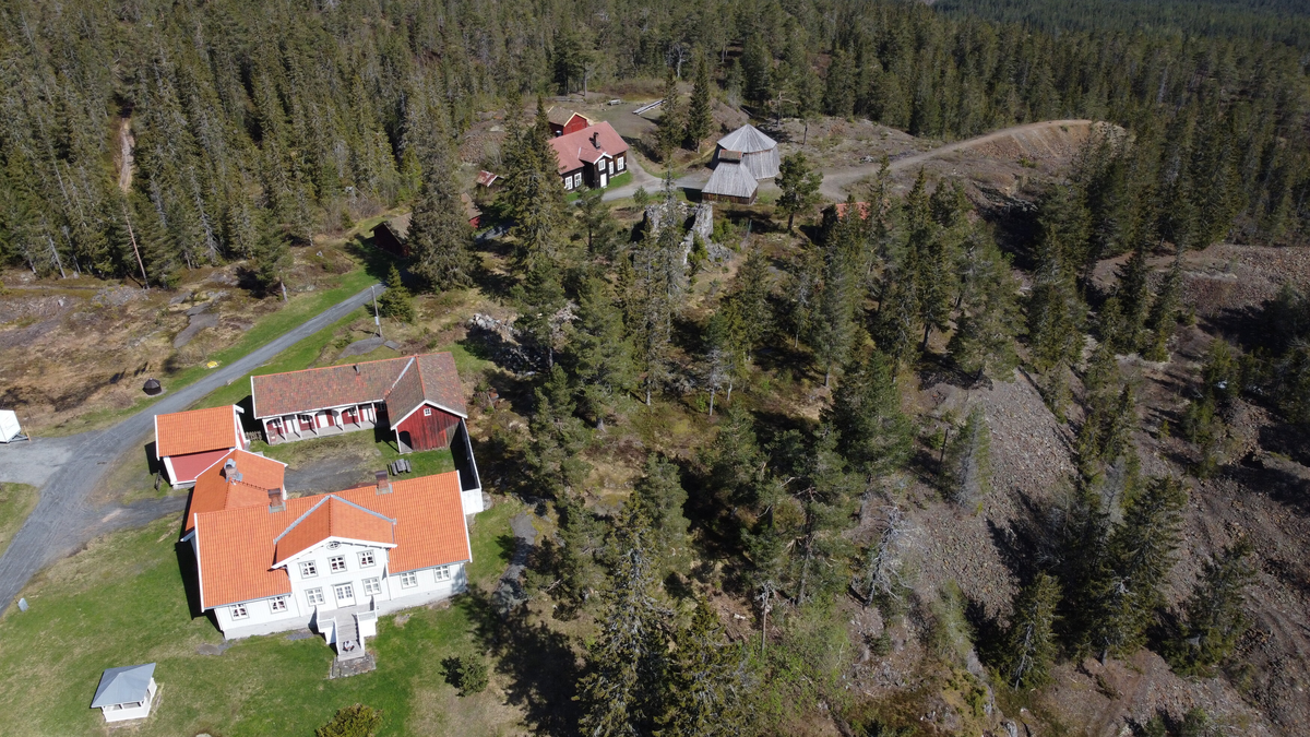 Laftet bygning i to etasjer med kjeller. Tegl på taket.