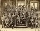 Förläggningen på Kungsholmen vid Hovjaktvarvet för Svea ingenjörkår. Underofficerskåren vid Kungl Svea ingenjörbataljon, 1890-talet. Till vänster om trappan: stående 4:e fr v Selmander. sittande 1:a fr v Tibbelin. På trappan: stående bakre raden fr v Söderberg, Carly, Johansson, Norrlöw. Stående mellersta raden Roos. Sittande fr v Jäderlund, Säfström, Samuelsson. Till höger om trappan: stående fr v Grönberg, Svensson, Dahlberg, ?. Sittande fr v Blomgren, ?. Bilden tagen framför Stabsbyggnadens sjöveranda.