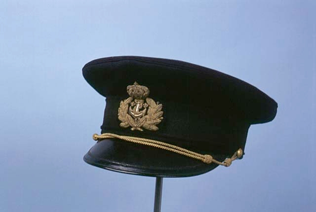 Mössa med skärm av blått kläde. M/1948 för kommendörkapten av andra graden, Kungl. Flottan.
Mössa med skärm av vitt tyg. M/1948 för kommendörkapten av andra graden, Kungl. Flottan.
Kläde; enfärgat, kraftigt ylletyg som valkats, ruggats, överskurits samt pressats, vilket givet en streckruggad, glansig yta. Det har använts till bl.a militäruniformer, kappor och klänningar.