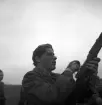 Hemvärnet. 20/4, 1941.
En ung man justerar något på sitt gevär.