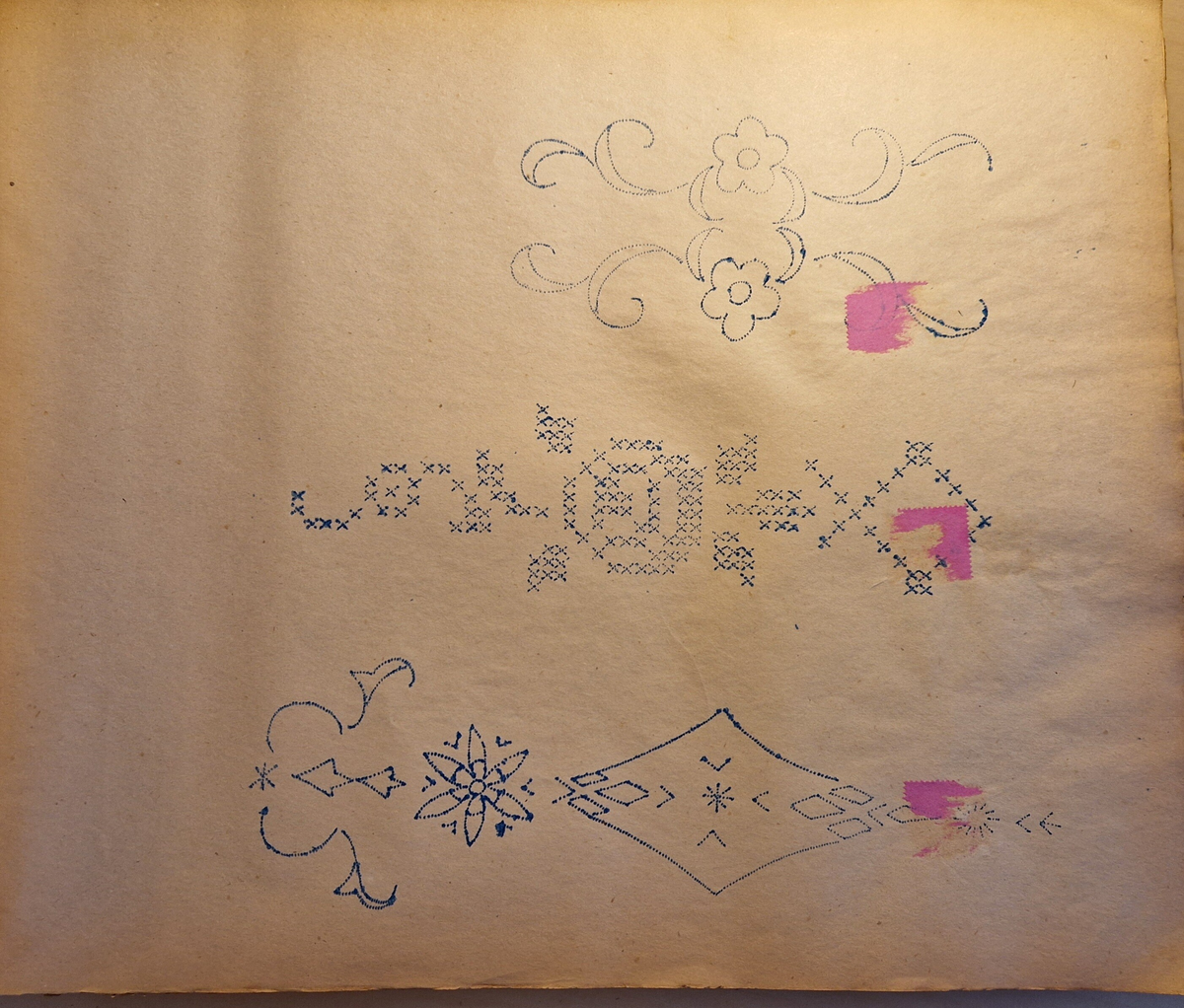 Varukatalog med broderimönster. Innehåller c:a 130 mönster + två "bokmärken." Svart pärm, mycket skadad. 