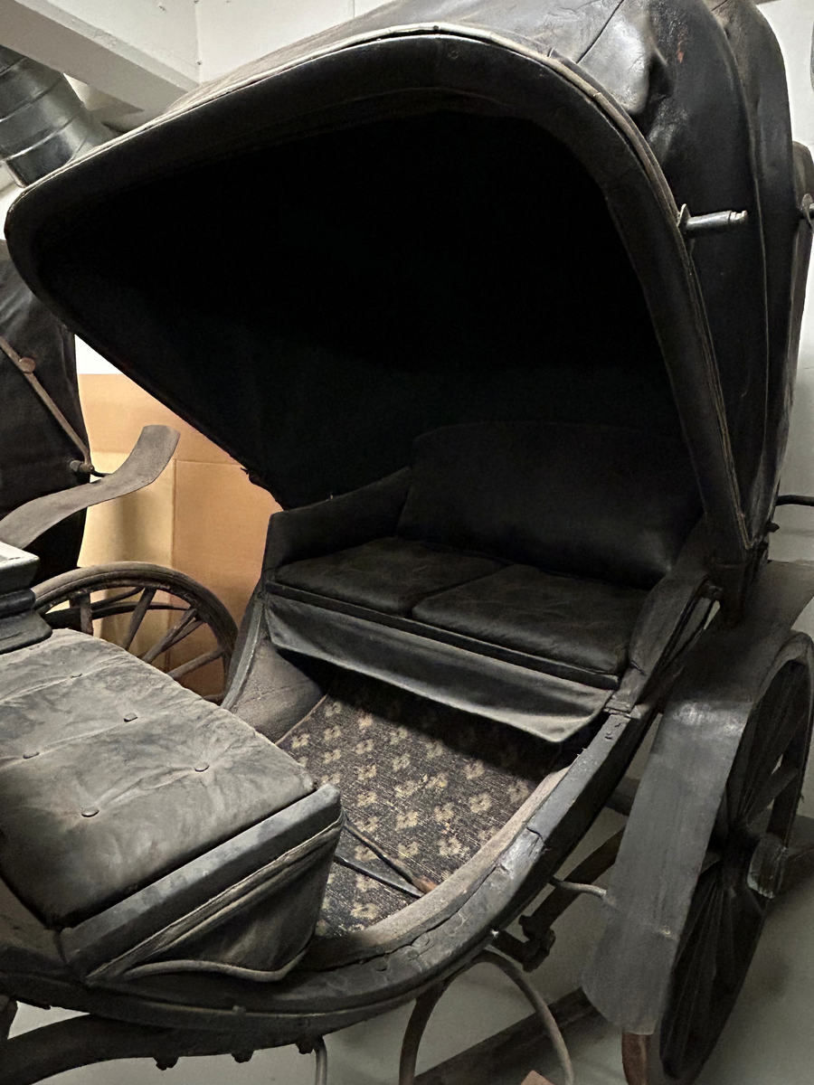 Svartmålad fyrhjulig hästvagn. Vagnen har öppen läderklädd kuskbock och sufflett över passagerarplatsen. Suffletten går att fälla bakåt vilket gör att hela vagnen är öppen. Svarta läderklädda säten för både framåt och bakåtresande. Fotsteg på varje sida. Stänkskydd för alla hjulen. Bakhjulen större än framhjulen.