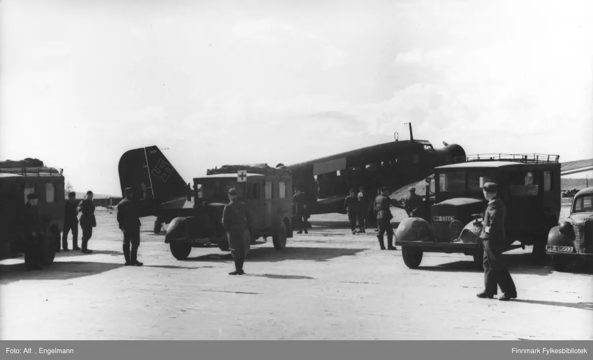 Tysk ambulansefly Junkers Ju 52/3m RK+AV (verknummer 5096) fra sanitetsflyberedskap 8 (San.Fl. Ber. 8) under syketransport. Kjøretøyene (Phänomen Granit 25) har registreringsskilt WH-387082 (eller 367082), WH-59863 og WH-1190153. 