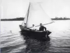 Tre personer ute och seglar med storekan 