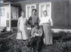 Fiskare Viktor Berg, framför sitt hus, med hustru Betty, adoptivsonen Vilgot och pigan i huset.