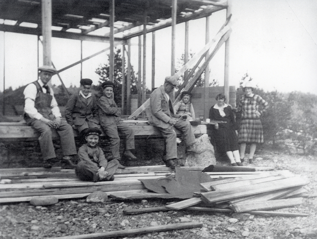 "Limöhäll", Limöns andra sommarstuga byggs 1928. Personer sitter på stugans stomme och tar rast.
