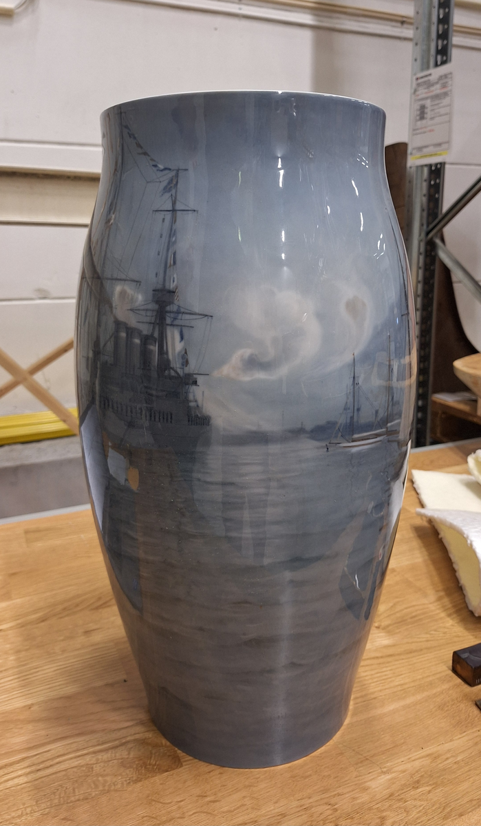 Vas av porslin dekorerad med hamnmotiv från Köpenhamn där man ser HM pansarkseppet Oscar II under relingsmaning, ett danskt kustpansarfartyg och en dansk hjuldriven lustyacht.