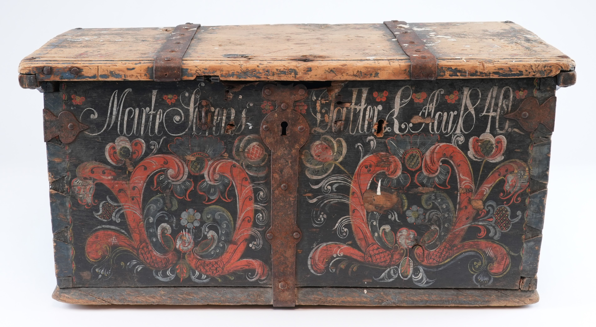 Kiste er rosemåla med alle kantar i blått og feltane mellom dei i svart. På begge sider av låsbeslaget på forsida måla symmetrisk dekorasjon. På svart bakgrunn raud rocaille (2 C-kurver mot kvarandre) med mange ulike blomstrar og blad som stikk ut av den. Blomstrane og blada måla i ulike fargar: kvit, gul, raud, blå, svart. På forsida over to rocaille inskripsjon måla i kvitt. Rocaille ornament gjentatt på de to kortsidene. Ornamenta liknar kvarandre som dannar ein homogen komposisjon, men kvert av dei er handmåla så de er forskjellige. På baksida berre svart bakgrunn og blå kantar.