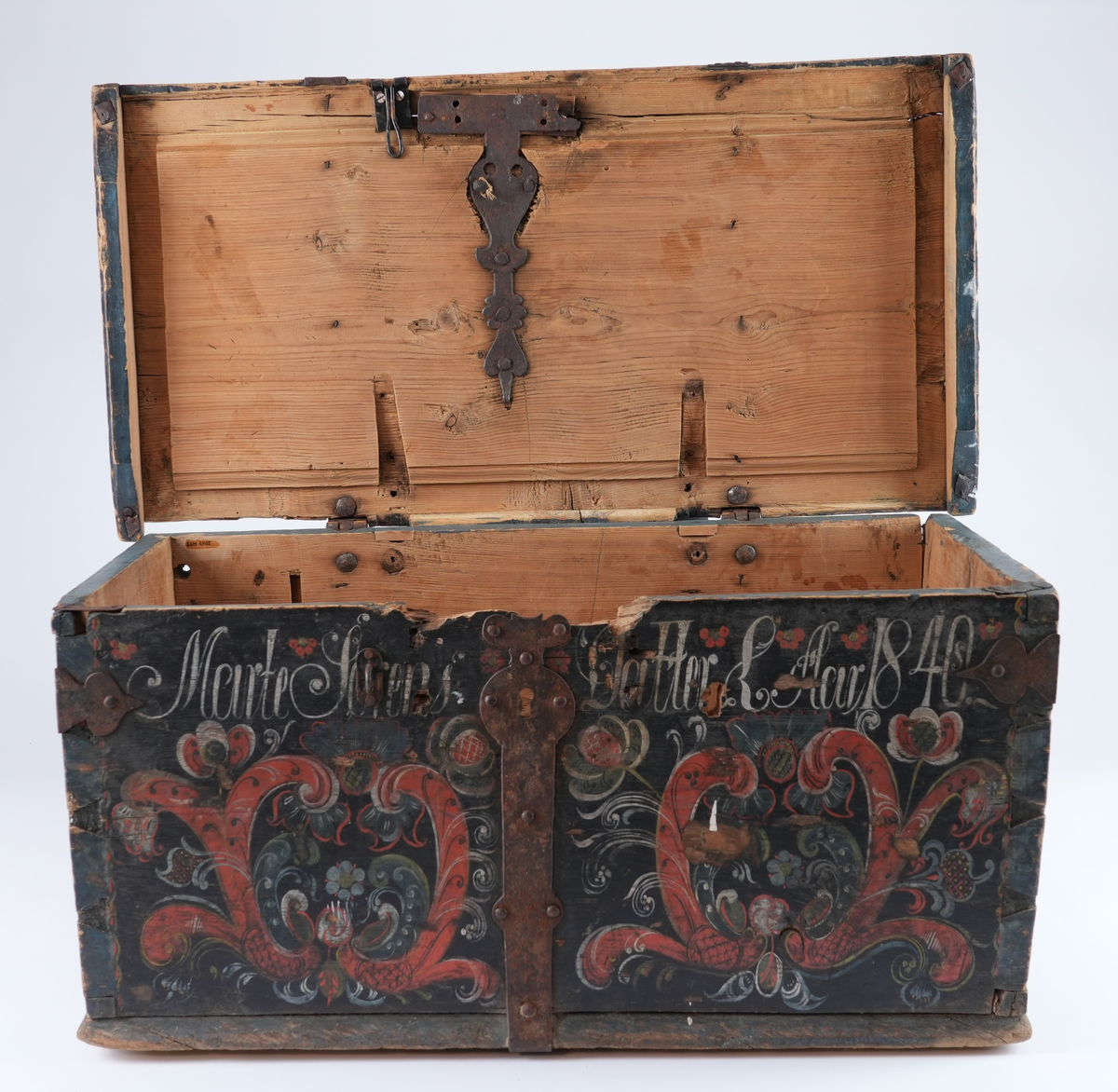 Kiste er rosemåla med alle kantar i blått og feltane mellom dei i svart. På begge sider av låsbeslaget på forsida måla symmetrisk dekorasjon. På svart bakgrunn raud rocaille (2 C-kurver mot kvarandre) med mange ulike blomstrar og blad som stikk ut av den. Blomstrane og blada måla i ulike fargar: kvit, gul, raud, blå, svart. På forsida over to rocaille inskripsjon måla i kvitt. Rocaille ornament gjentatt på de to kortsidene. Ornamenta liknar kvarandre som dannar ein homogen komposisjon, men kvert av dei er handmåla så de er forskjellige. På baksida berre svart bakgrunn og blå kantar.