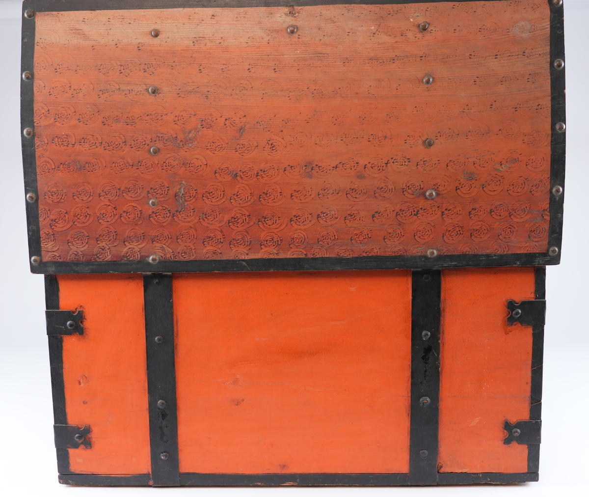 Heile kista måla vermilion. Fronten, kortsidene og loket tynt laserte med caput mortuum. I laseringa svamptrykk (vridde ringar). Alle kantar av kista er understreka med ei svart stripe som skal etterlikna beslaga.