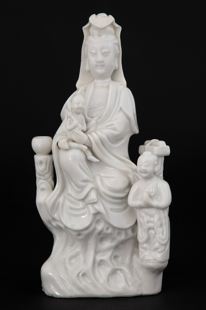 Figuren representerer den buddhistiske bodhisattavaen Guanyin, en barmhjertighetsgudinne. Hun er avbildet sittende med et barn i fanget, som holder en lotusknopp. Ved Gudinnens føtter ses en bedende person - antakelig en alkolytt (medhjelper i å utføre religiøse ritualer).