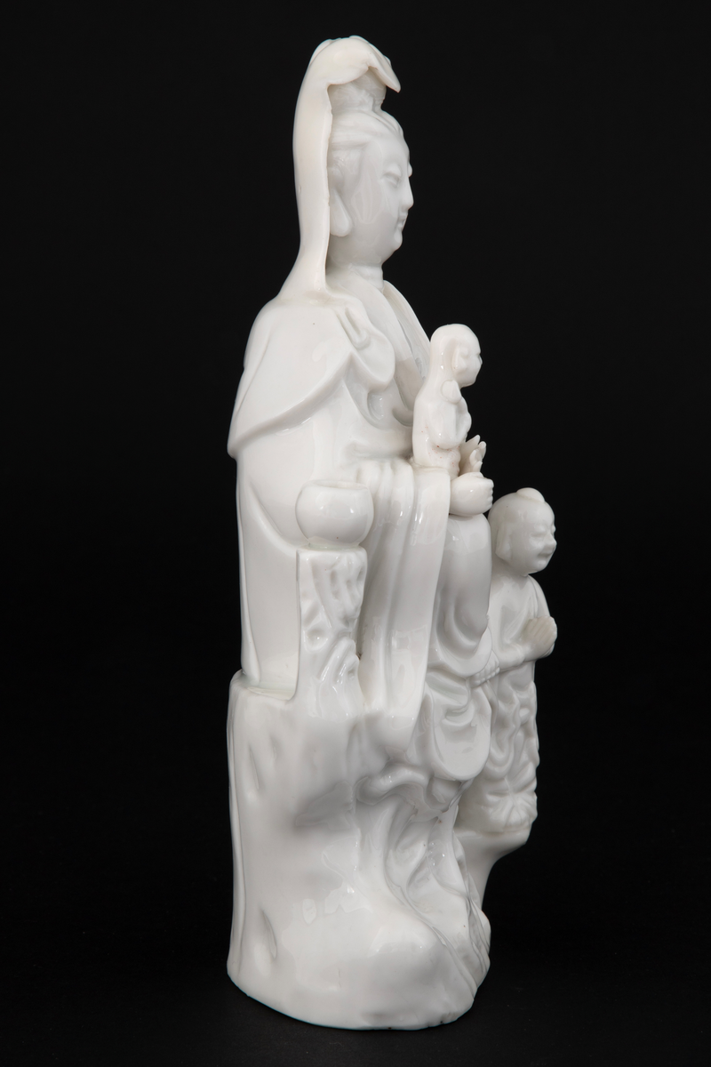 Figuren representerer den buddhistiske bodhisattavaen Guanyin, en barmhjertighetsgudinne. Hun er avbildet sittende med et barn i fanget, som holder en lotusknopp. Ved Gudinnens føtter ses en bedende person - antakelig en alkolytt (medhjelper i å utføre religiøse ritualer).