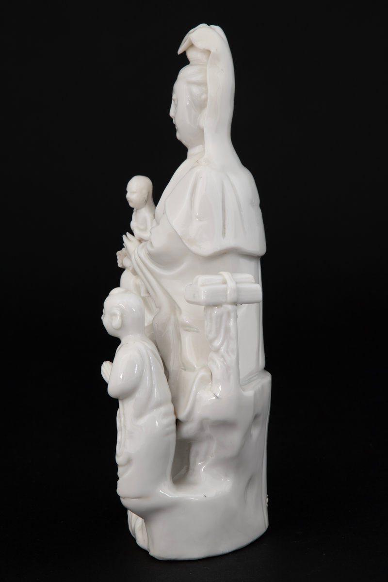 Figuren representerer den buddhistiske bodhisattavaen Guanyin, en barmhjertighetsgudinne. Hun er avbildet sittende med et barn i fanget, som holder en lotusknopp. Ved Gudinnens føtter ses en bedende person - antakelig en alkolytt (medhjelper i å utføre religiøse ritualer).