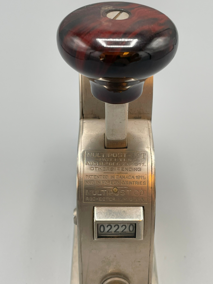 Frankeringsmaskin av amerikansk tillverkning, handtagsknopp av trä.

Multipost no T
Patented
Aug 8 and Dec 19 1911
Others pending
-----
Patented in Canada,
and in foreign countries
Multipost Co