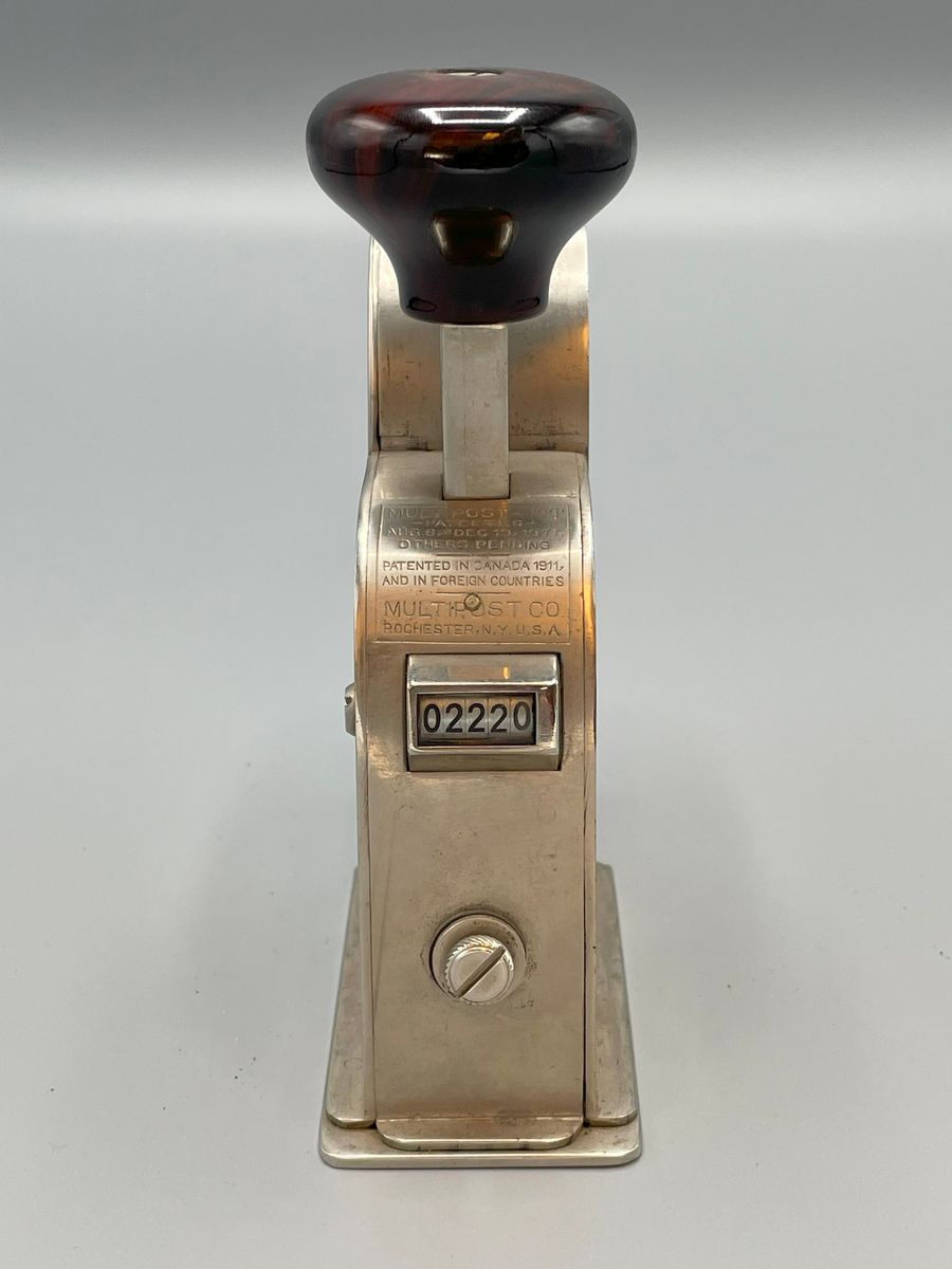 Frankeringsmaskin av amerikansk tillverkning, handtagsknopp av trä.

Multipost no T
Patented
Aug 8 and Dec 19 1911
Others pending
-----
Patented in Canada,
and in foreign countries
Multipost Co