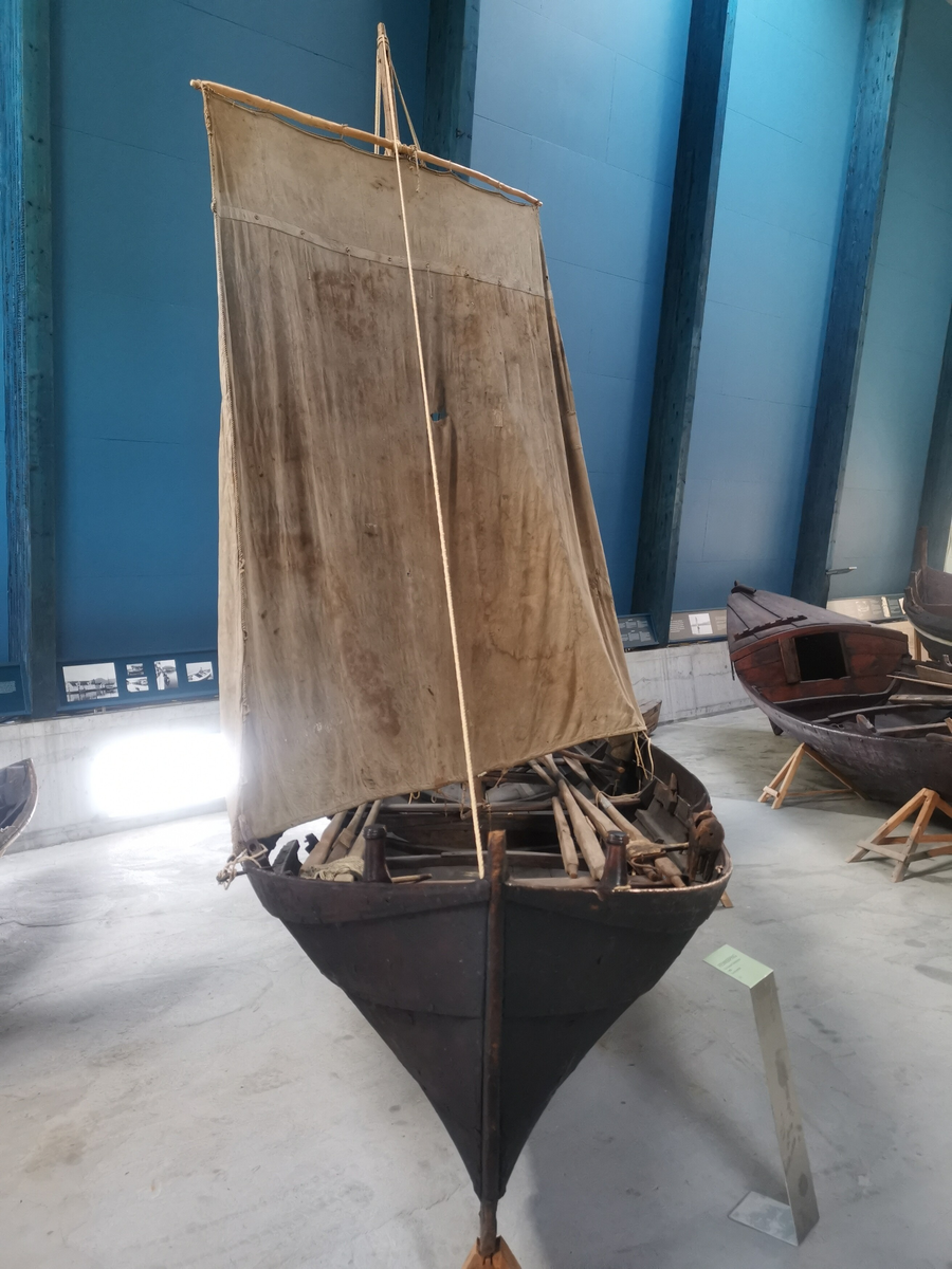 Klinkbygd sunnfjordbåt. Det er ein femkeiping/tiæring med 4,5 rom og 5 omfar. Tjæra utvendig og innvendig, med mørk brun farge. Båten har relativt smal kjølsu. Fint utført med dekorlinjer og ornamentering. Båten har størrelse som ein femkeiping, men har berre 4 keipepar - slagkeiping.