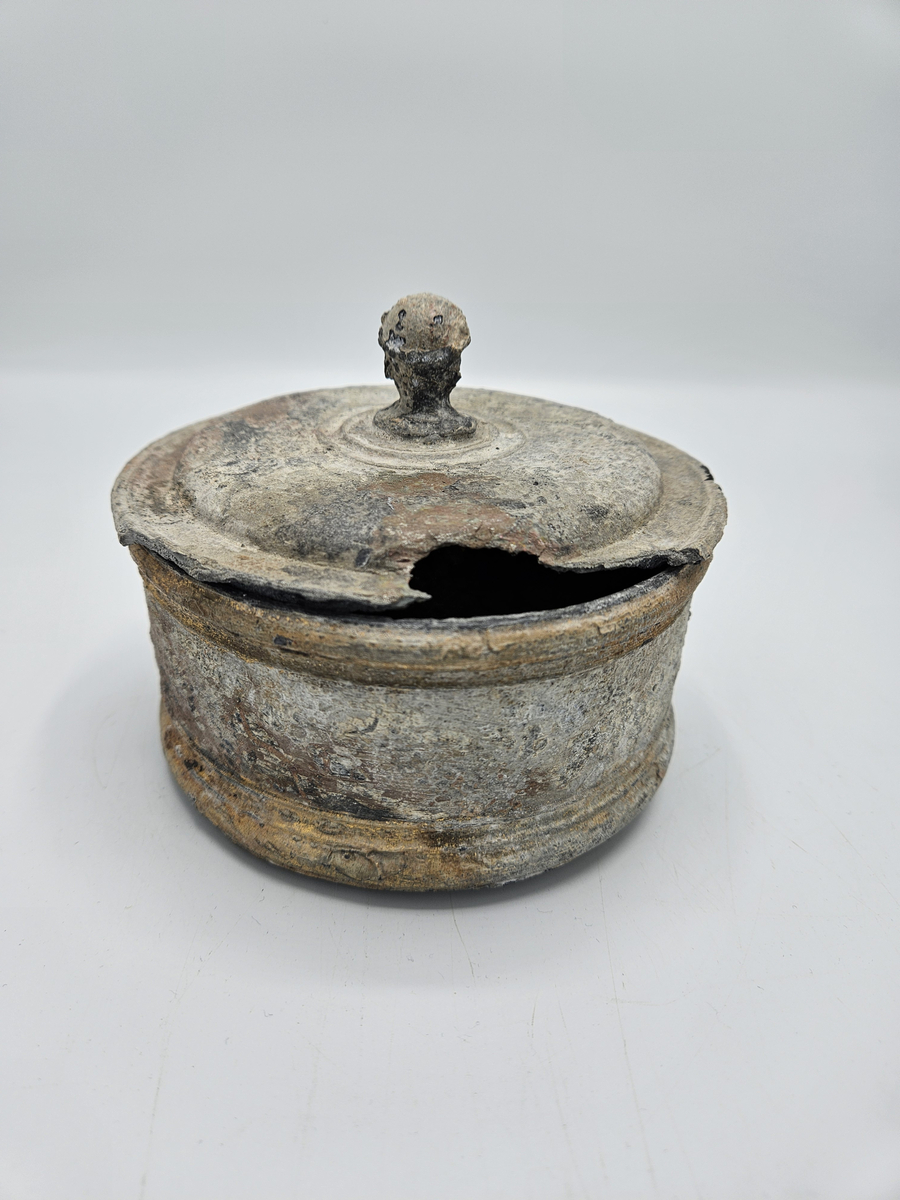 Tobaksburk med innerlock, som sjunker med innehållet och därvid håller det fräscht , prytt med drake i brons/guldfärg. Ytterlocket har en knopp i form av manshuvud med huvudbonad som liknar turban? Ytterlocket något skadat , alt angripet efter några hundra år på havets botten. Se övrig info.
