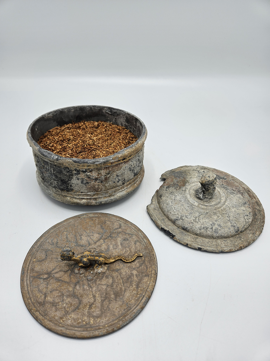 Tobaksburk med innerlock, som sjunker med innehållet och därvid håller det fräscht , prytt med drake i brons/guldfärg. Ytterlocket har en knopp i form av manshuvud med huvudbonad som liknar turban? Ytterlocket något skadat , alt angripet efter några hundra år på havets botten. Se övrig info.